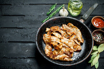 Fried bacon with tomato sauce.