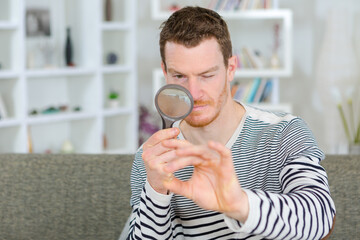 man holding a magnifying glass and magnifying viewer ring