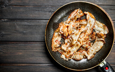 Fried bacon in a frying pan.
