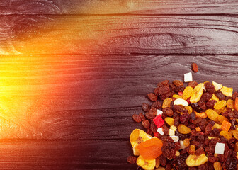 wooden background in retro style. a mixture of dried fruits lies on it. close-up. there is a...