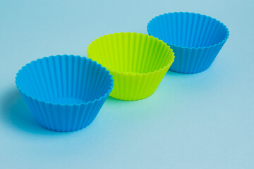 Yellow and blue silicone cupcake molds on a soft blue paper background