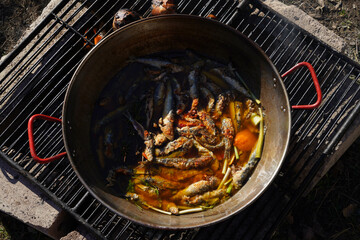chopped pan filled with pickled sardines cooked on fire