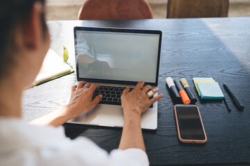 Crop freelancer working on laptop