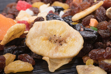 wooden background in retro style. a mixture of dried fruits lies on it. close-up. there is a tinting. soft focus.