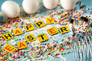 Multicolored sprinkles on turquoise background, festive decoration for banner, poster, flyer, card, card, cover, brochure with the inscription "Easter" in multicolored letters