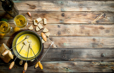 Delicious fondue cheese with bread slices and white wine.