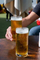Fresh draught lager or IPA beer is glass served in outdoor cafe close up, pint of beer close up