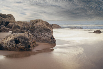 stones on the ocean shore. ocean at sunset. sea waves and beach