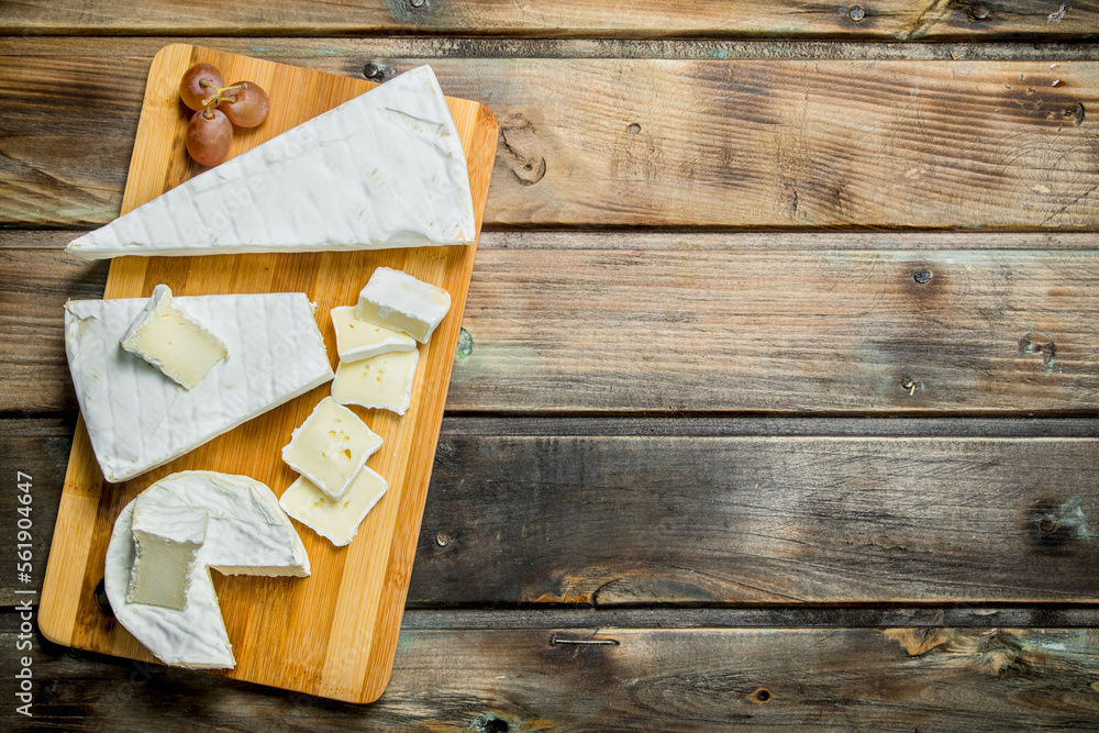 Poster Brie cheese on the chopping Board.