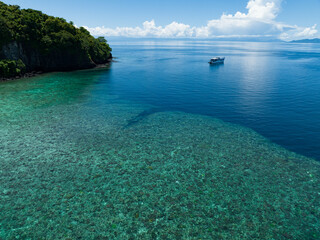 A coral reef fringes a lush, tropical islands found in a remote part of the Solomon Islands. This...