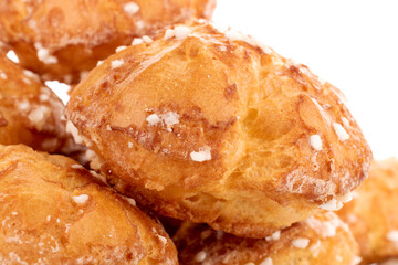 Several sweet chouquettes, close-up, isolated on white.