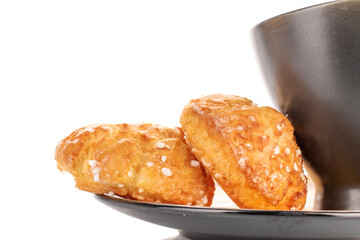 Two sweet chouquette with a cup on a saucer, close-up, isolated on white.