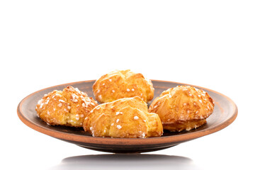 Several sweet chouquette on a clay plate, close-up, isolated on white.