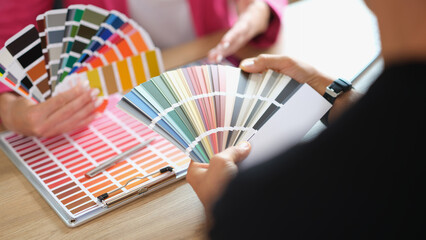 Designer helps client choose colors for project from variety.