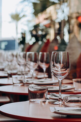 Laid table on a restaurant terrace with palm trees in the background