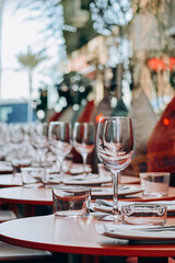 Laid table on a restaurant terrace with palm trees in the background