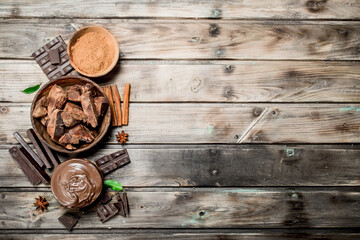 Fototapeta na wymiar Chunks of crushed chocolate with chocolate paste and ground cocoa.