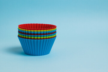 Set of new colorful silicone baking molds on blue paper background