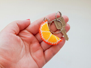 Fruit keychain lies on a woman's palm