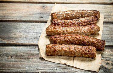 Grill sausages on paper .