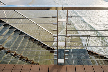 Metal fence and handrails on an outdoor staircase near the sea.