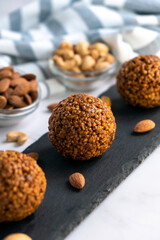 Healthy raw dessert, bliss balls of nuts cashew and almonds on black rock board. Energy balls for healthy eating. Gluten off, sugar free candies made of nuts.