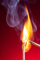 Match igniting another on red gradient background.