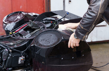 Washing a motorcycle with a high pressure jet.