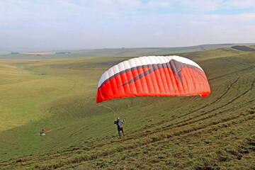 	
Paraglider launching from on a hill	