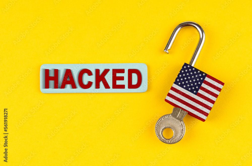 Poster on the yellow surface is an open lock with a key and a sticker with the inscription - hacked