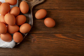 Raw brown chicken eggs on wooden table, flat lay. Space for text
