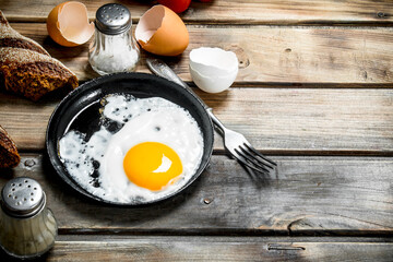 Fried egg in a pan with rye bread.