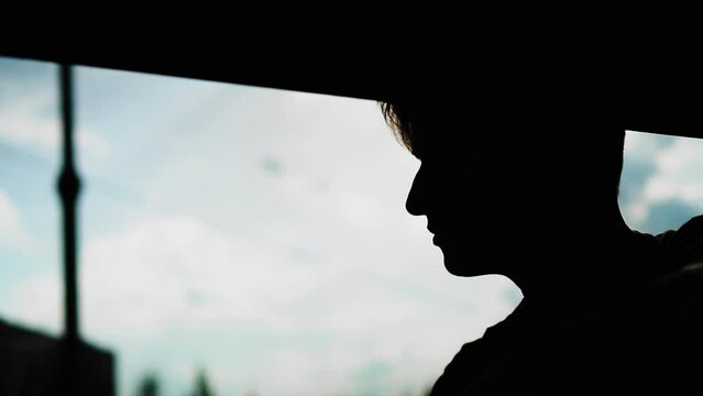 The silhouette of a guy's face with a thoughtful face against the sky. Very thoughtful and cool profile