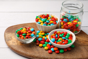 Tasty colorful candies on white wooden table