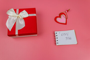 Red gift box, Valentine heart and notepad with handwritten text 
