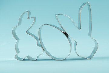 Easter bunny on blue background. Happy Easter Day concept. Minimal Easter concept. Space for text. Easter Cookie Cutter on baking background.