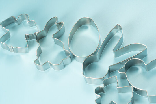 Easter bunny on blue background. Happy Easter Day concept. Minimal Easter concept. Space for text. Easter Cookie Cutter on baking background.