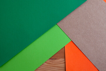 Paper green, orange, brown kraft and wood texture, empty background, geometrically located. Creative plain concept slight. Color blank for presentations, copy space.