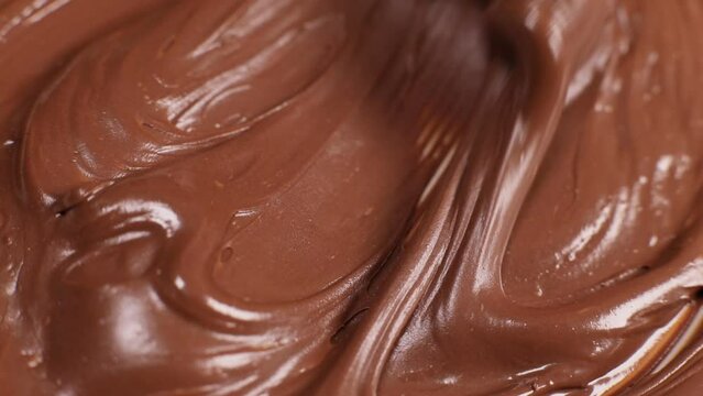 Knife stirs chocolate hazelnut butter slow motion