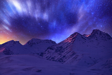 Fantasy night landscape. Beautiful snow covered mountains in the starry night with milky way galaxy.