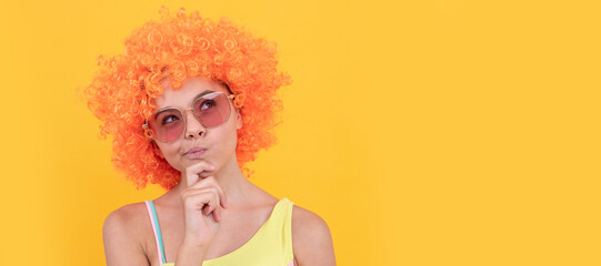 thinking kid in curly clown wig. having fun. thoughtful child wear sunglasses and swimsuit. Funny teenager child on party, poster banner header with copy space.