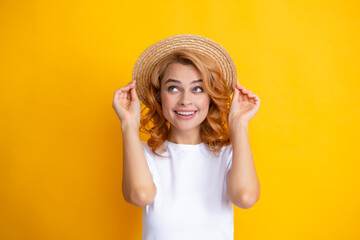 Portrait of funny woman in stylish straw hat on yellow background.