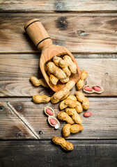 Fototapeta premium Peanuts in a wooden scoop .