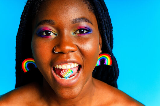 young woman wearing colorful blouse standing isolated over blue background, lgbt concept