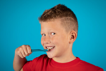 Cute Boy Brushing Teeth With Toothbrush And Looking At Camera