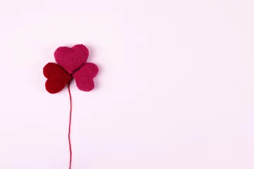 Poster Red crocheted hearts are laid out in the shape of a flower clover on a lilac background. Happy Valentine's Day, Mother's Day and birthday greeting card. © Katya Slavashevich