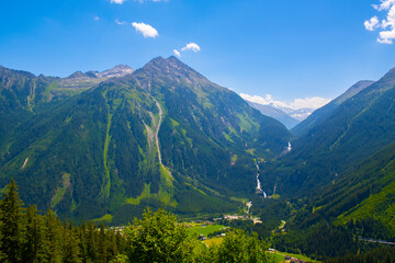Fototapeta na wymiar Panoramic view of idyllic mountain scenery in the Alps with fresh green meadows in bloom on a beautiful sunny day in springtime