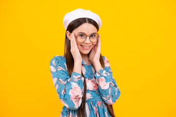 Happy teenager, positive and smiling emotions. Teenager child wearing glasses on yellow studio background. Cute girl in eyeglasses.