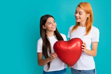 Fototapeta na wymiar Love mom. Happy mothers day. Child daughter is congratulating mom and giving her heart balloon. Mum and child teenager girl smiling. Family holiday.