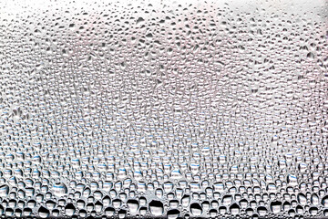 Water condensate drops on window glass.Drops of condensed steam on a transparent surface of glass or plastic.Window glass with condensation.Texture of water